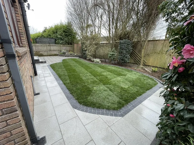 Landscaped garden with paving and fresh turf by JT Landscapes